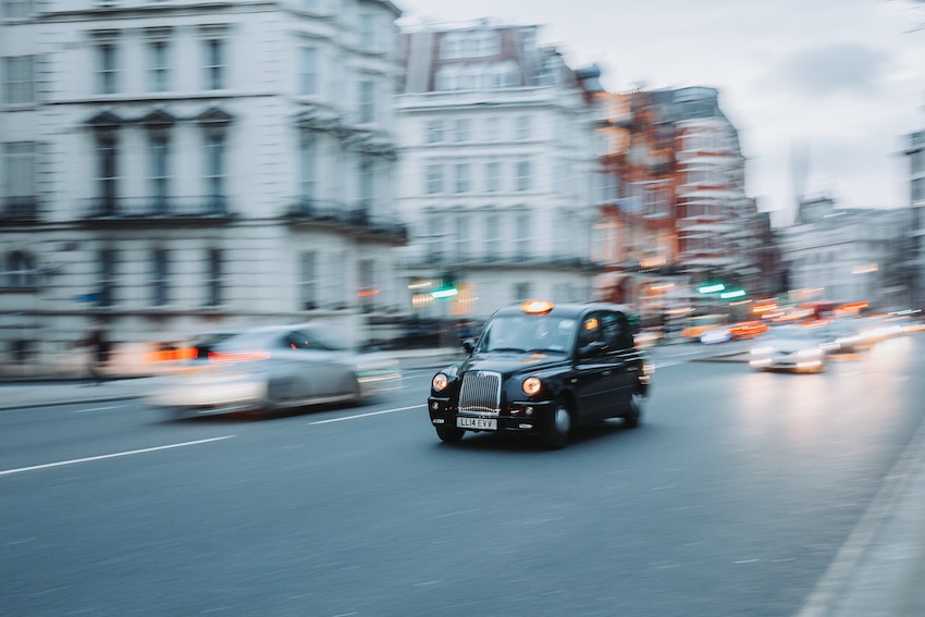 Táxi tradicional de Londres em rua com fundo desfocado