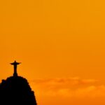 Silhueta do Cristo Redentor, Rio de Janeiro, com céu em tons de laranja